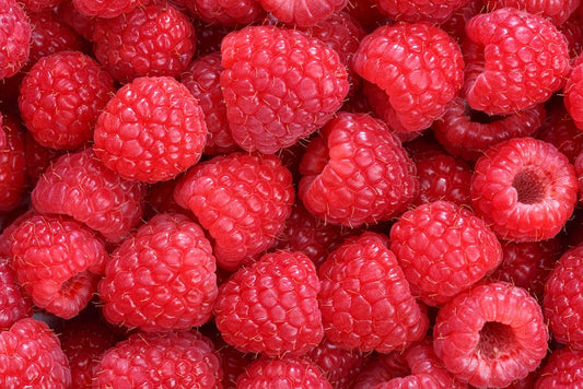 Primo piano di lamponi freschi e maturi che mostrano il loro colore rosso brillante e la consistenza dettagliata.