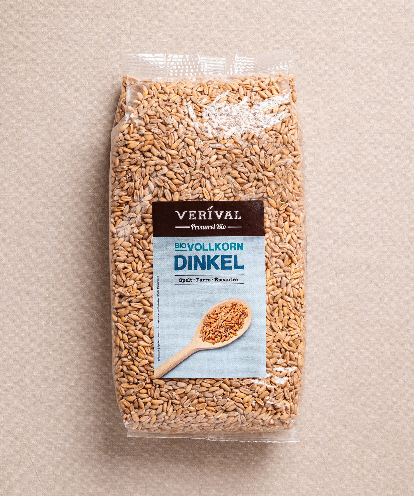 Der Dinkel von Verival Bio ist in einem durchsichtigen Folienbeutel verpackt. Auf dem Etikett ist ein Holzlöffel mit Dinkelkörnern abgebildet.