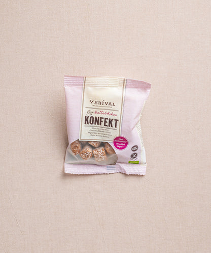 Eine Packung Dattel-Kokos Konfekt von Verival Bio, mit 100% Bio-Datteln, liegt auf einer beigen Oberfläche.