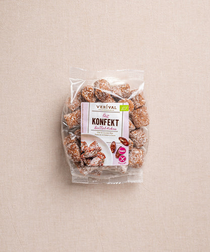 Die Verpackung des Dattel-Kokos Konfekts von Verival Bio hebt den veganen Snack mit sichtbaren Dattel- und Kokosstücken auf heller Oberfläche hervor.