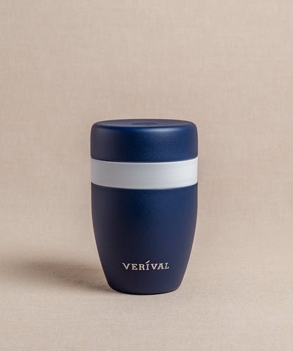 Ein dunkelblauer FLSK Thermosbecher To Go mit einem auffälligen weißen Band um die Mitte, elegant platziert auf einem neutralen Hintergrund.