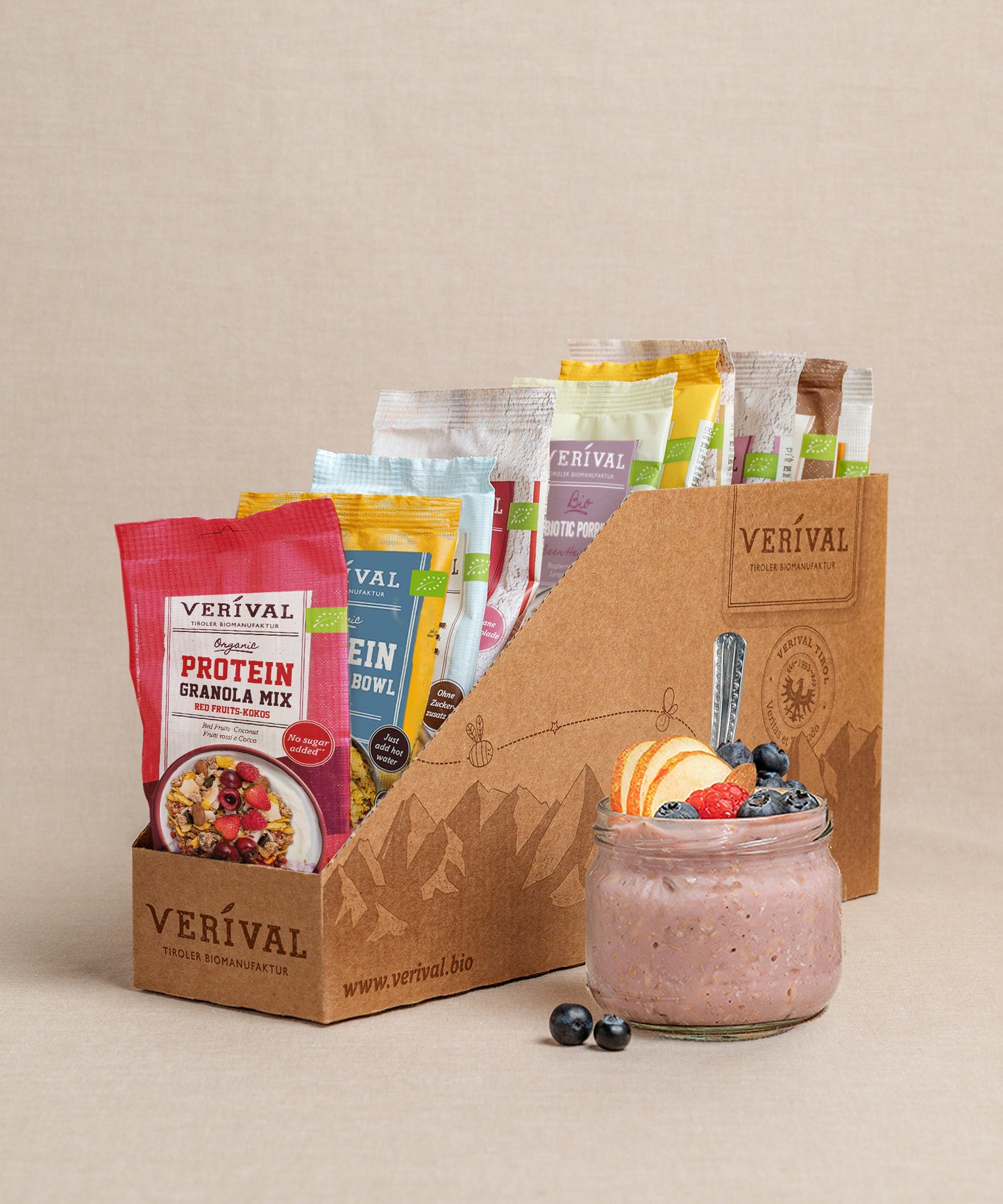 Die Protein-Probierbox Top 10 von Verival Bio enthält 10 verschiedene Einzelportionspackungen von proteinreichen Verival Frühstücksprodukten,  inklusive Granols und Müslia. Davor präsentiert ein Glas Haferflocken mit Früchten ein proteinreiches Frühstück, das perfekt zur Unterstützung deiner Fitnessziele geeignet ist.