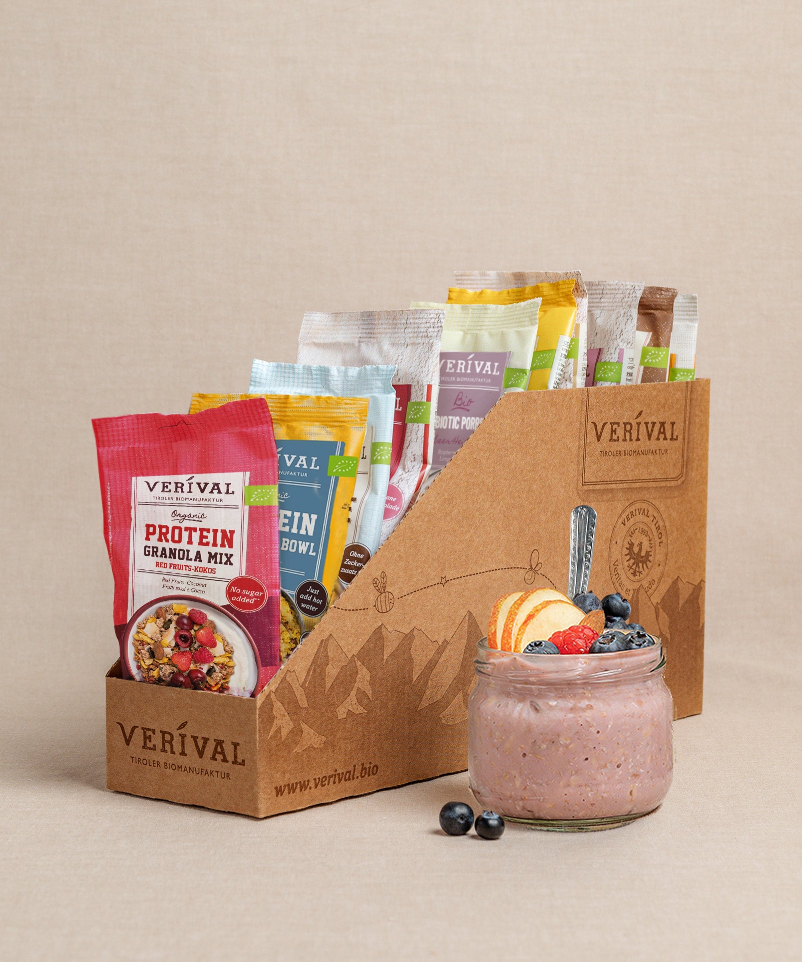Die Protein-Probierbox Top 10 von Verival Bio enthält 10 verschiedene Einzelportionspackungen von proteinreichen Verival Frühstücksprodukten,  inklusive Granols und Müslia. Davor präsentiert ein Glas Haferflocken mit Früchten ein proteinreiches Frühstück, das perfekt zur Unterstützung deiner Fitnessziele geeignet ist.